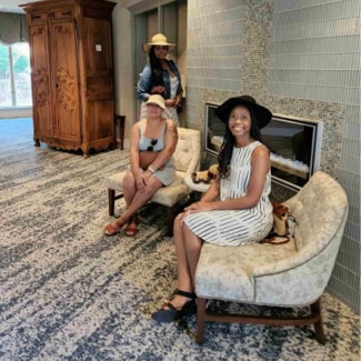 3 woman sitting an a lobby looking excited